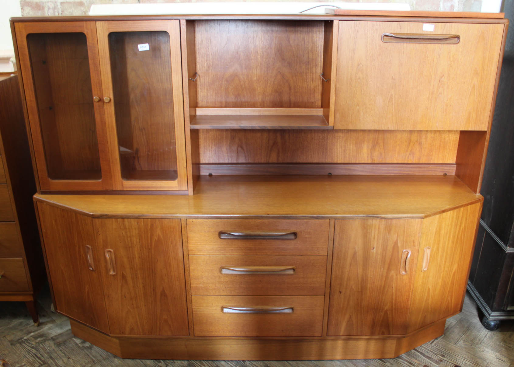 A G-Plan sideboard with part glazed and shelves top and three Ercol style dining chairs