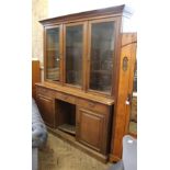 A substantial Edwardian oak cupboard bookcase with three drawers with open centre to base