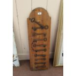 Ten antique iron keys on wooden plaque