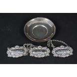 A set of three silver decanter labels and a small silver dish