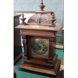 A carved mahogany striking mantel clock with brass dial