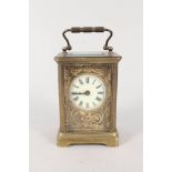 A brass cased carriage clock with relief cherub and floral decorated dial