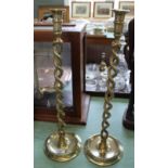 A large pair of late Victorian open barley twist brass candlesticks with wide dished circular bases,