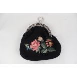 A lady's wool work reticule with continental white metal floral frame and clasp