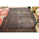 A Persian maroon ground rug with central medallions,