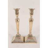 A pair of late 18th Century Adam style brass or bell metal candlesticks with beaded decoration on