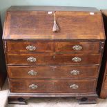 A Georgian burr oak veneered bureau standing on unusual ogee feet,