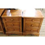 A pair of hardwood bedside chests of three drawers