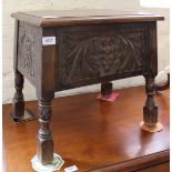 A 1940's carved oak stool with lift top lid