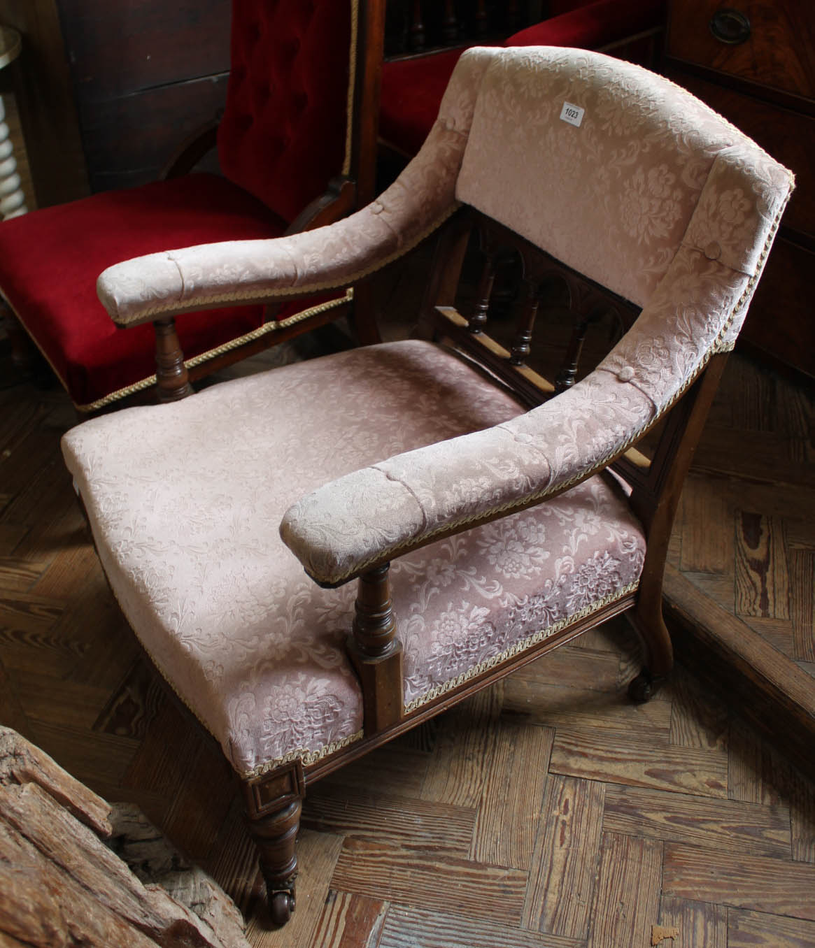 An Edwardian mahogany low arm chair with pink upholstery