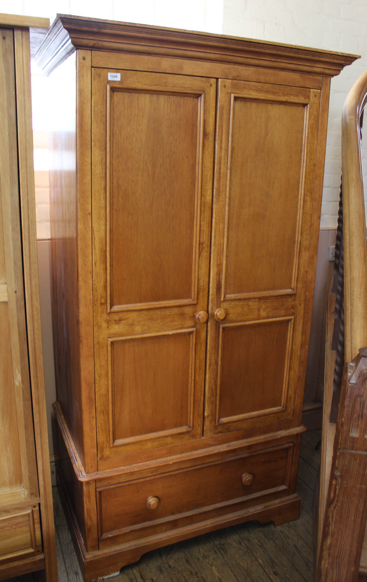 A modern hardwood double wardrobe with single drawer to base