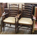 A pair of oak ladder back carvers with rushed seats