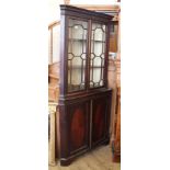 An Edwardian mahogany corner cabinet with astragal glazed top on cupboard base