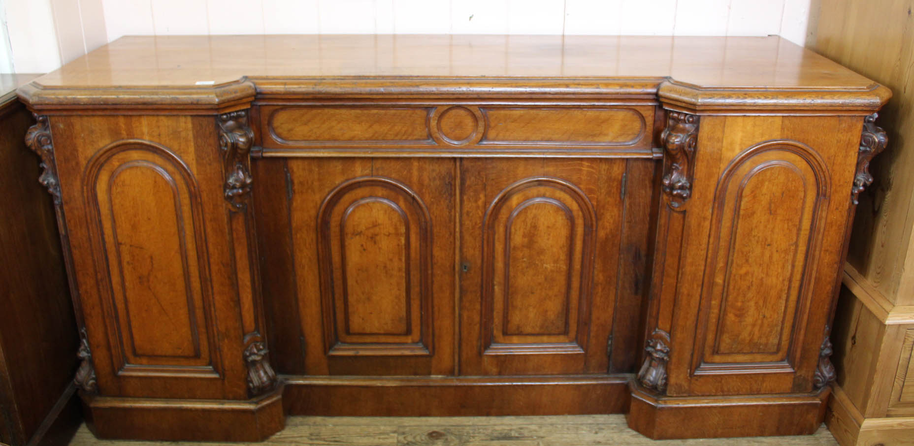 A substantial four door Victorian carved oak shaped front sideboard with single drawer