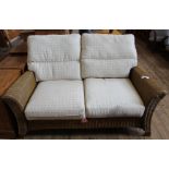A cream upholstered cane conservatory sofa