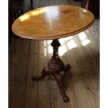 A Victorian carved walnut tripod table with burr walnut oval top