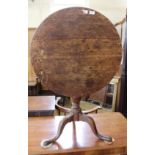 A Victorian oak tripod flip top table