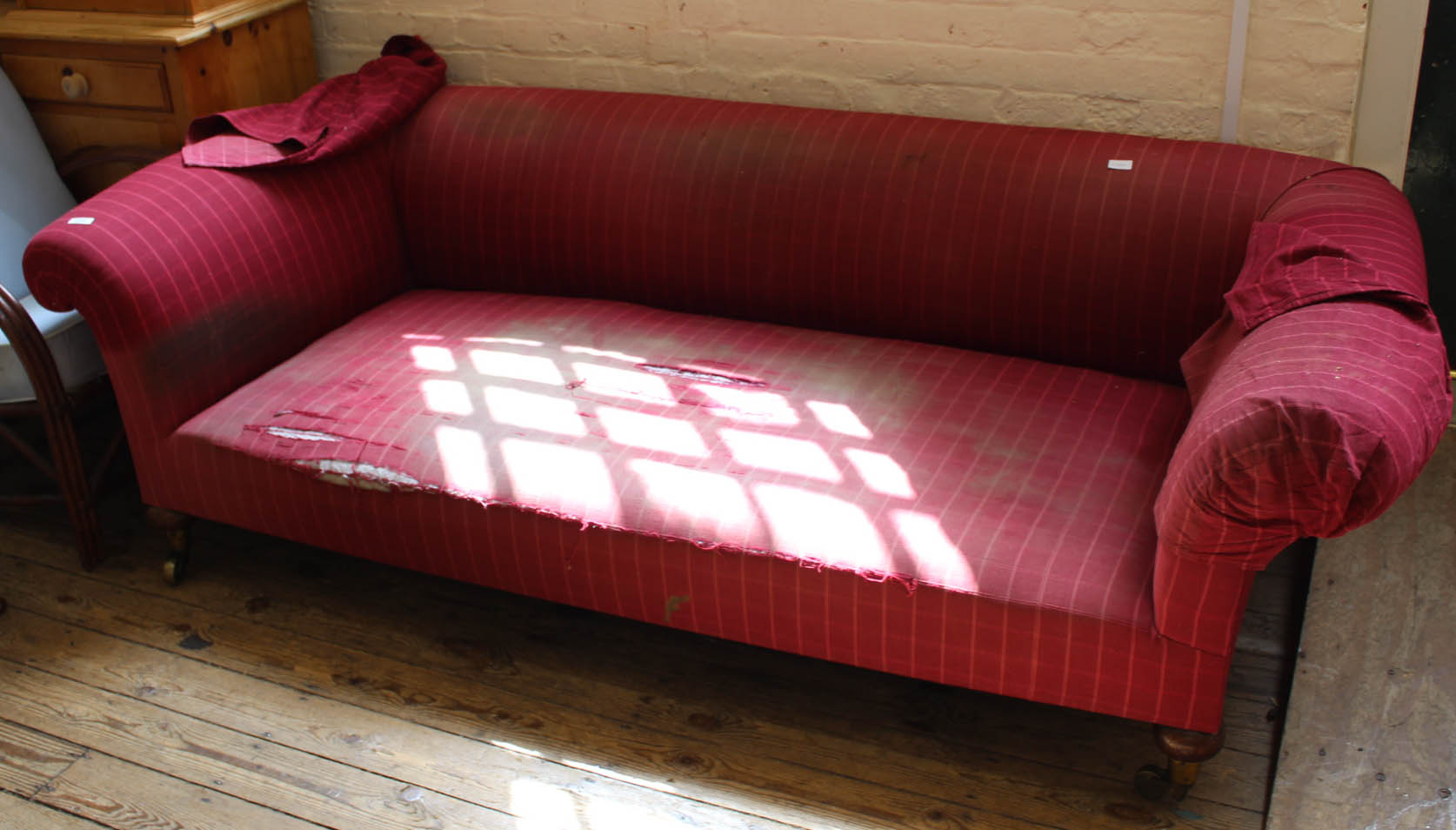 A substantial Chesterfield standing on original brass castors with red check upholstery