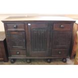 A 19th Century carved oak three door cupboard with four drawers on turned feet