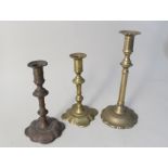 A pair of 18th Century petal based brass candlesticks plus one other