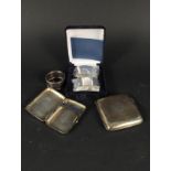 A boxed pair of silver napkin rings, two small silver cigarette cases,