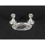 A pair of dwarf silver candlesticks together with an embossed silver trinket dish