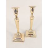 A pair of late 18th Century Adam style brass candlesticks on square bases,