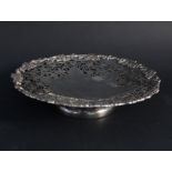 An ornately pierced silver tazza with vine leaf and grape decoration around the stylised star