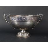 A large two handled silver punch bowl with embossed figural decoration to top rim on flared base,