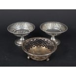 A pair of silver pierced bon bon dishes on pedestal bases and another silver pierced dish on three