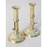 A pair of early 18th Century side ejector brass candlesticks on domed circular bases,
