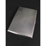 A large silver cigarette case with engine turned decoration,