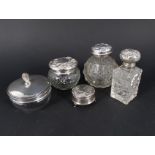 Four silver lidded cut glass dressing table items including powder pot and a silver ring box (all