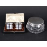 A cut glass silver lid powder bowl plus a pair of cased silver serviette rings