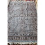 A Persian Bokhara blue ground rug plus a machine made floral carpet