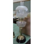 A brass column oil lamp with cut glass bowl and etched globe