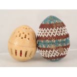 A beaded egg containing miniature bone dominoes and a bone egg containing miniature rosary