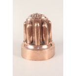 A tall Victorian copper jelly mould with eight turrets,