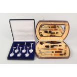A cased set of six silver plated spoons with transport related terminals plus a manicure set