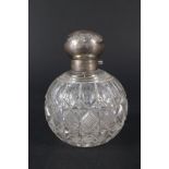A large cut glass globular scent bottle with silver lid,