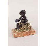 A bronzed and gilt metal seated putto on variegated marble base,