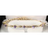 A 14ct gold line bracelet set with tanzanite and diamonds,