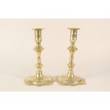 A pair of 18th Century seamed brass candlesticks by Joseph Wood with knopped stems and petal shaped