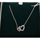 An 18ct white gold diamond set double heart pendant on an 18ct white gold chain