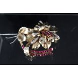 A large continental yellow metal floral spray brooch set with rubies and diamonds