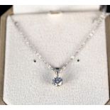 A solitaire diamond pendant set in white gold on a platinum chain