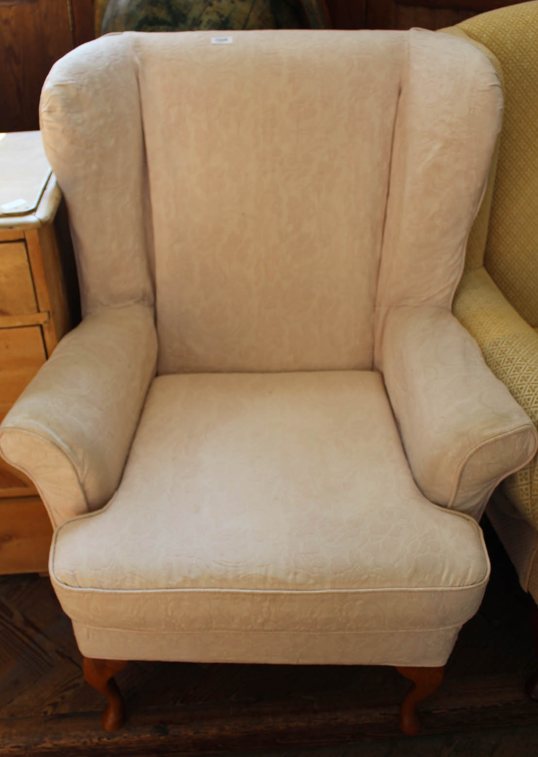 A reproduction wingback armchair with pale pink upholstery
