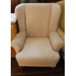 A reproduction wingback armchair with pale pink upholstery