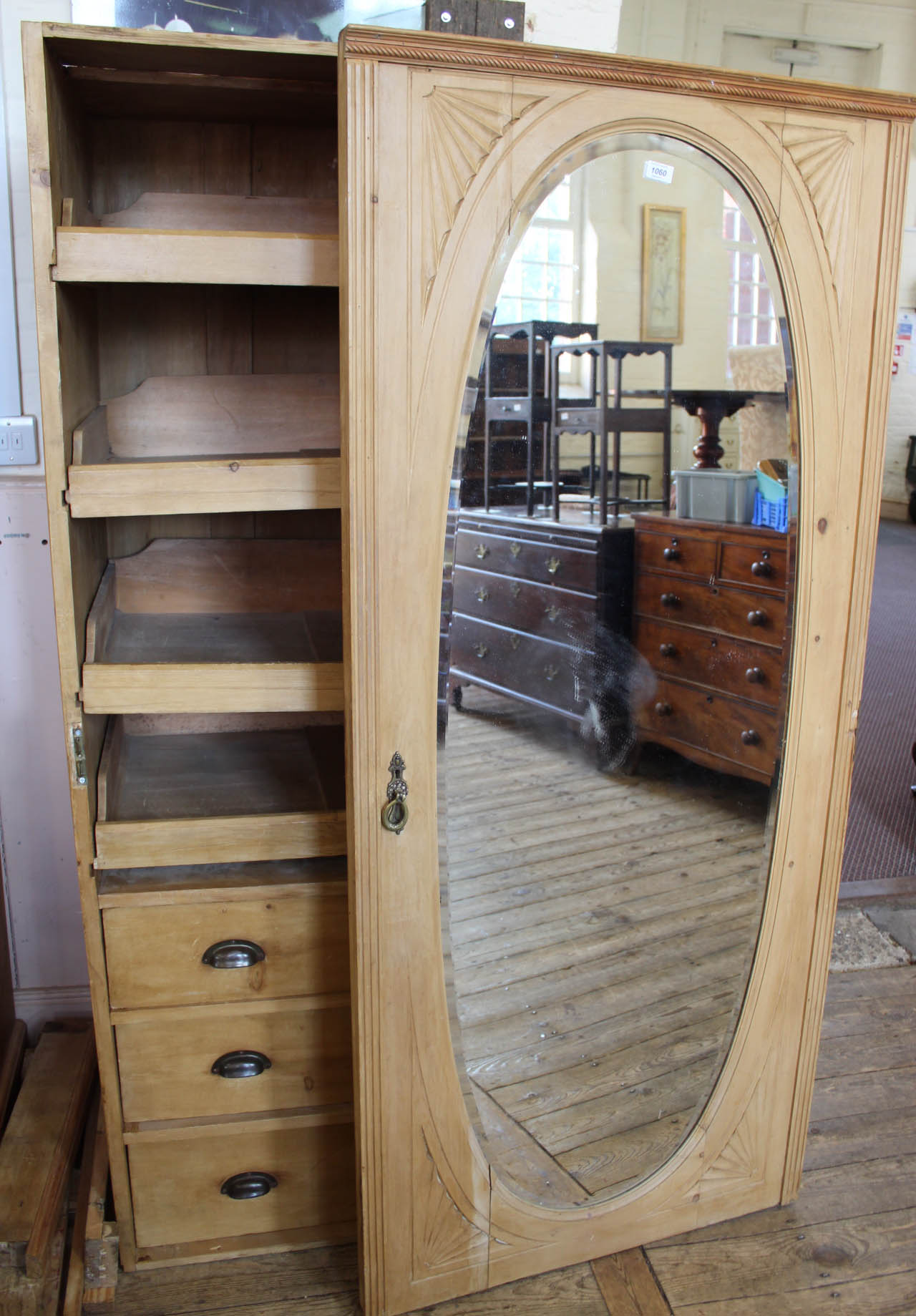 The middle section of a pine triple wardrobe with oval mirror,