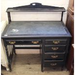 An Edwardian ebonised desk with five drawers and shelved upstand